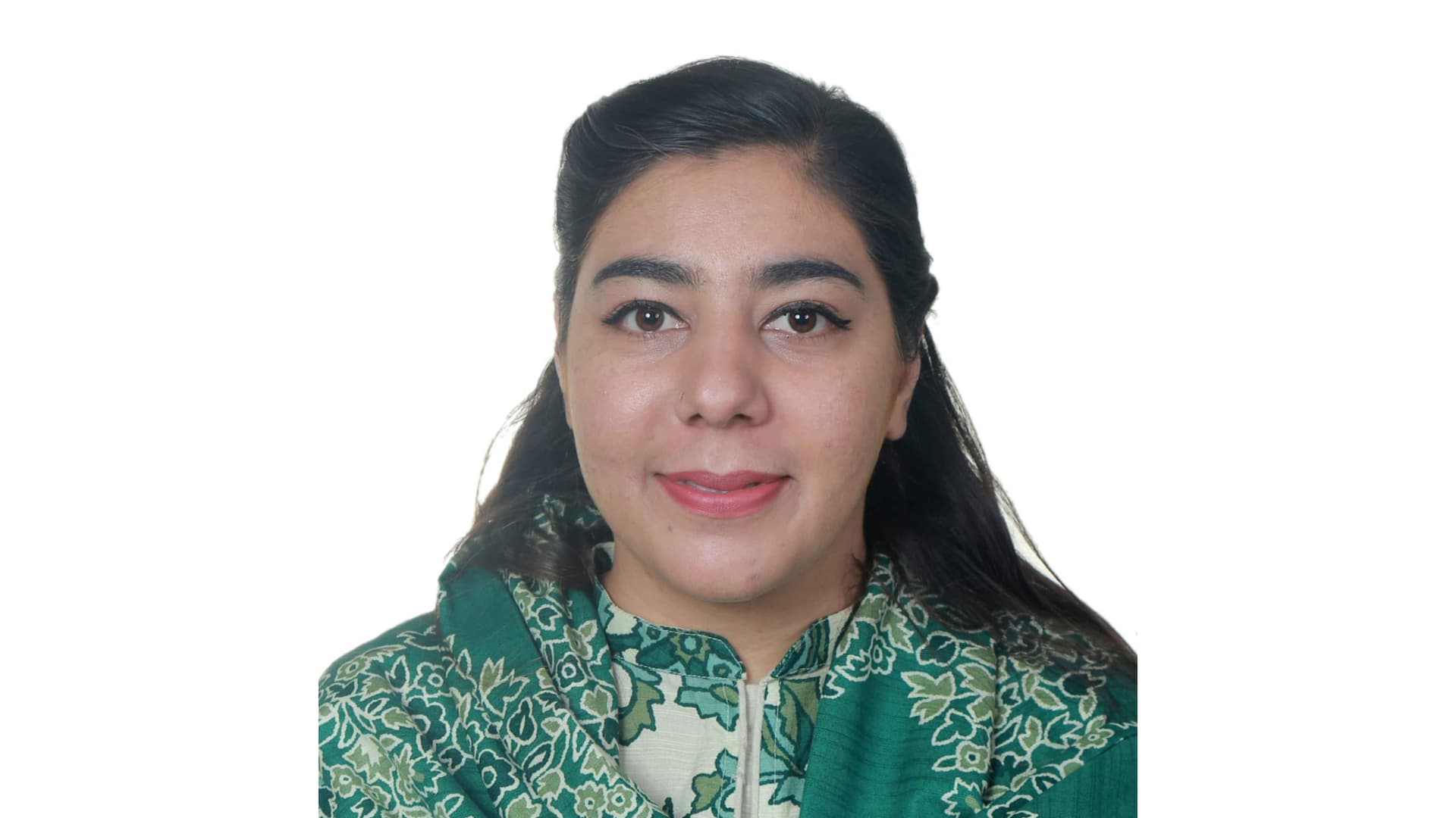 Sadia Qudrat has dark shoulder-length hair that is pulled back and wears a floral green top. The background is white.