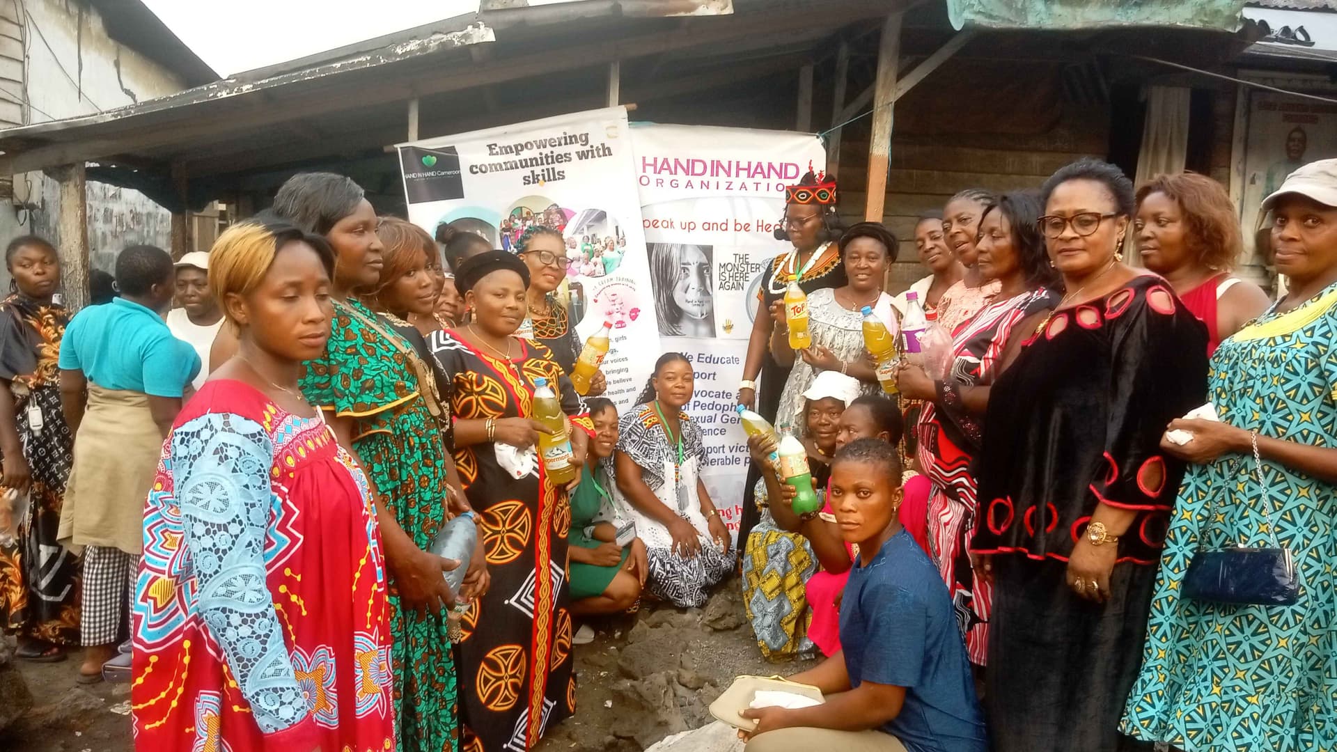 Some women holding some of the liquid soap produced 